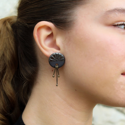 Handmade stud earrings from black porcelain with brass wires that hangs
