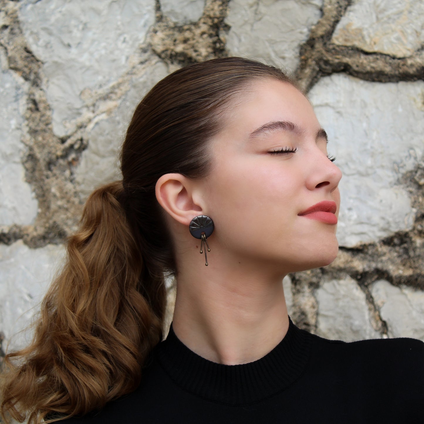 Handmade stud earrings from black porcelain with brass wires that hangs