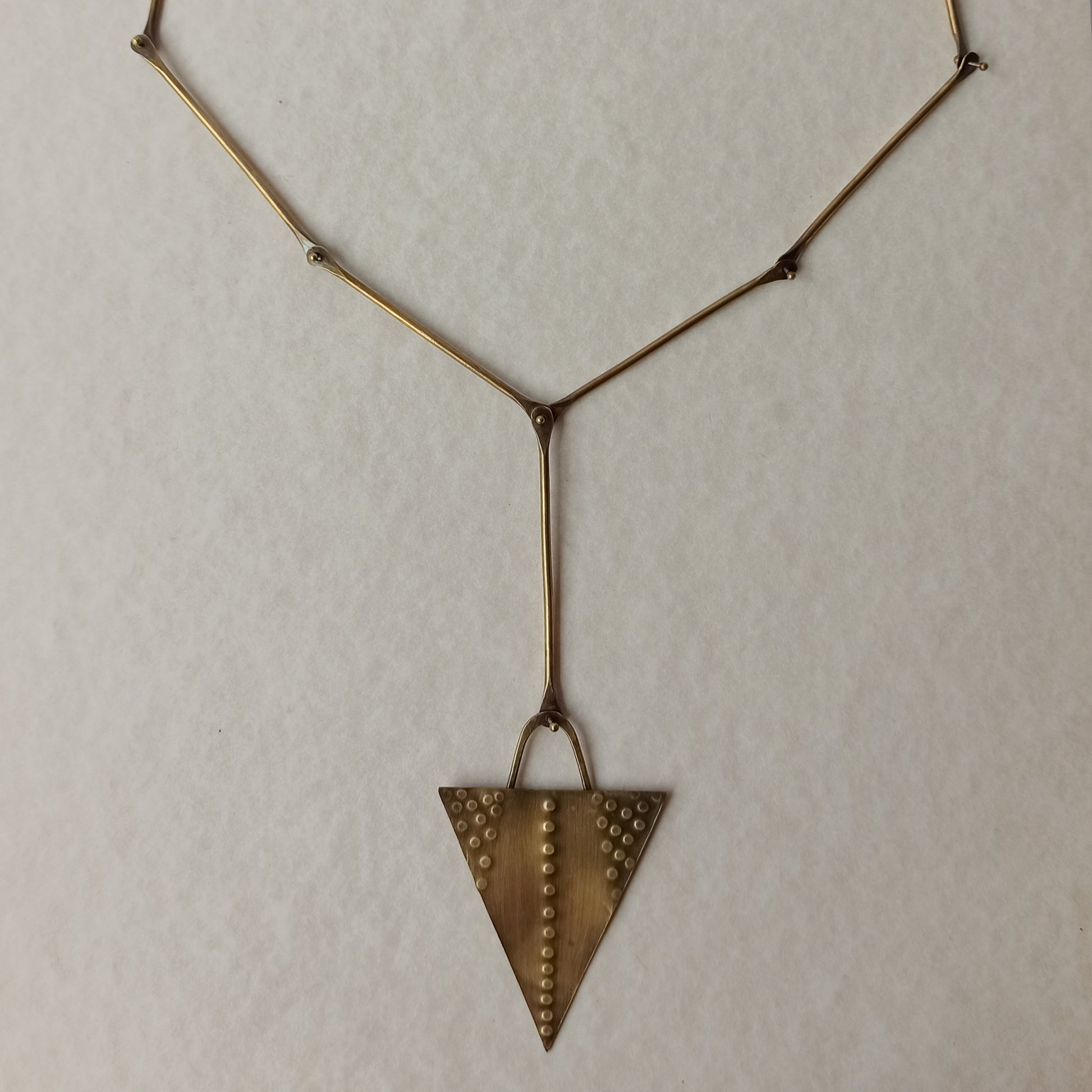 Handmade long necklace from oxidized brass. The center part is made from handtextured brass sheet and the chain is handmade from brass wire. The part that rests on the neck is from black satin cord. A lariat style totally handmade necklace ideal to make your outfit stand out.