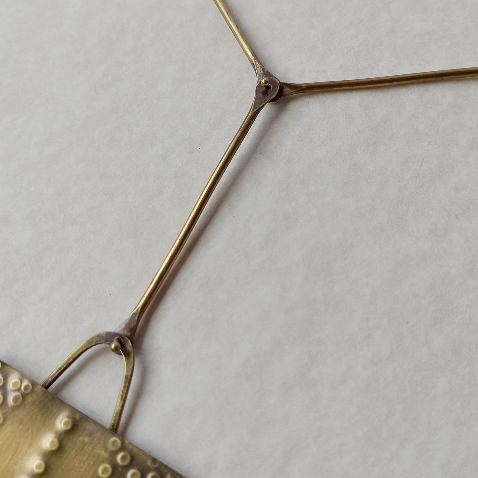 Handmade long necklace from oxidized brass. The center part is made from handtextured brass sheet and the chain is handmade from brass wire. The part that rests on the neck is from black satin cord. A lariat style totally handmade necklace ideal to make your outfit stand out.