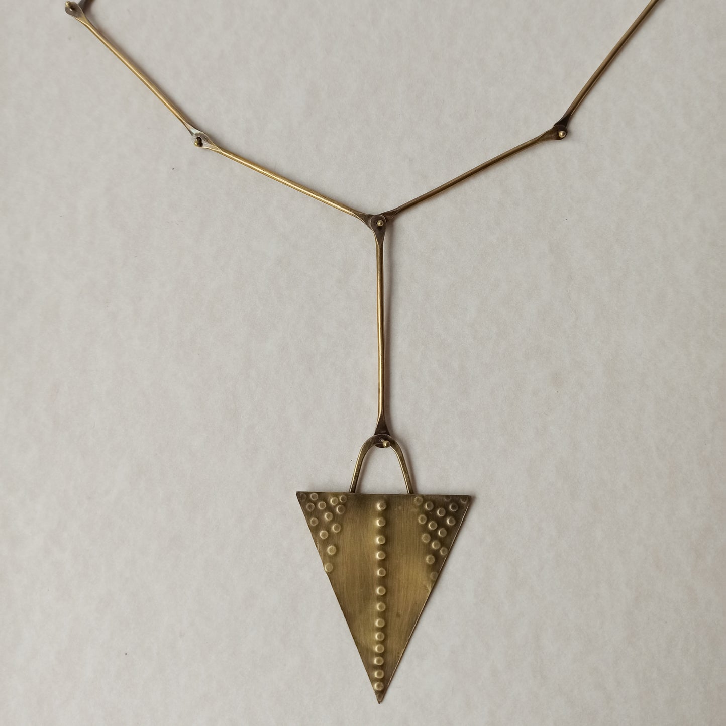 Handmade long necklace from oxidized brass. The center part is made from handtextured brass sheet and the chain is handmade from brass wire. The part that rests on the neck is from black satin cord. A lariat style totally handmade necklace ideal to make your outfit stand out.