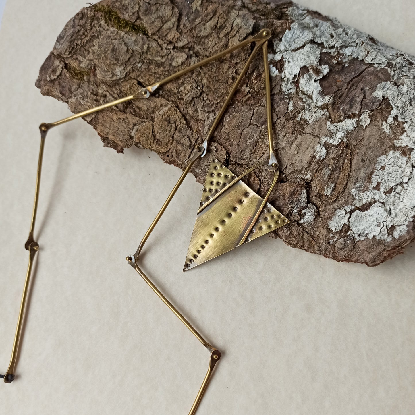 Handmade long necklace from oxidized brass. The center part is made from handtextured brass sheet and the chain is handmade from brass wire. The part that rests on the neck is from black satin cord. A lariat style totally handmade necklace ideal to make your outfit stand out.