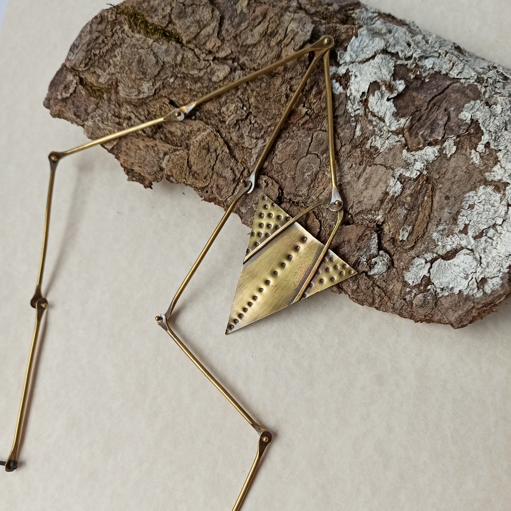 Handmade long necklace from oxidized brass. The center part is made from handtextured brass sheet and the chain is handmade from brass wire. The part that rests on the neck is from black satin cord. A lariat style totally handmade necklace ideal to make your outfit stand out.