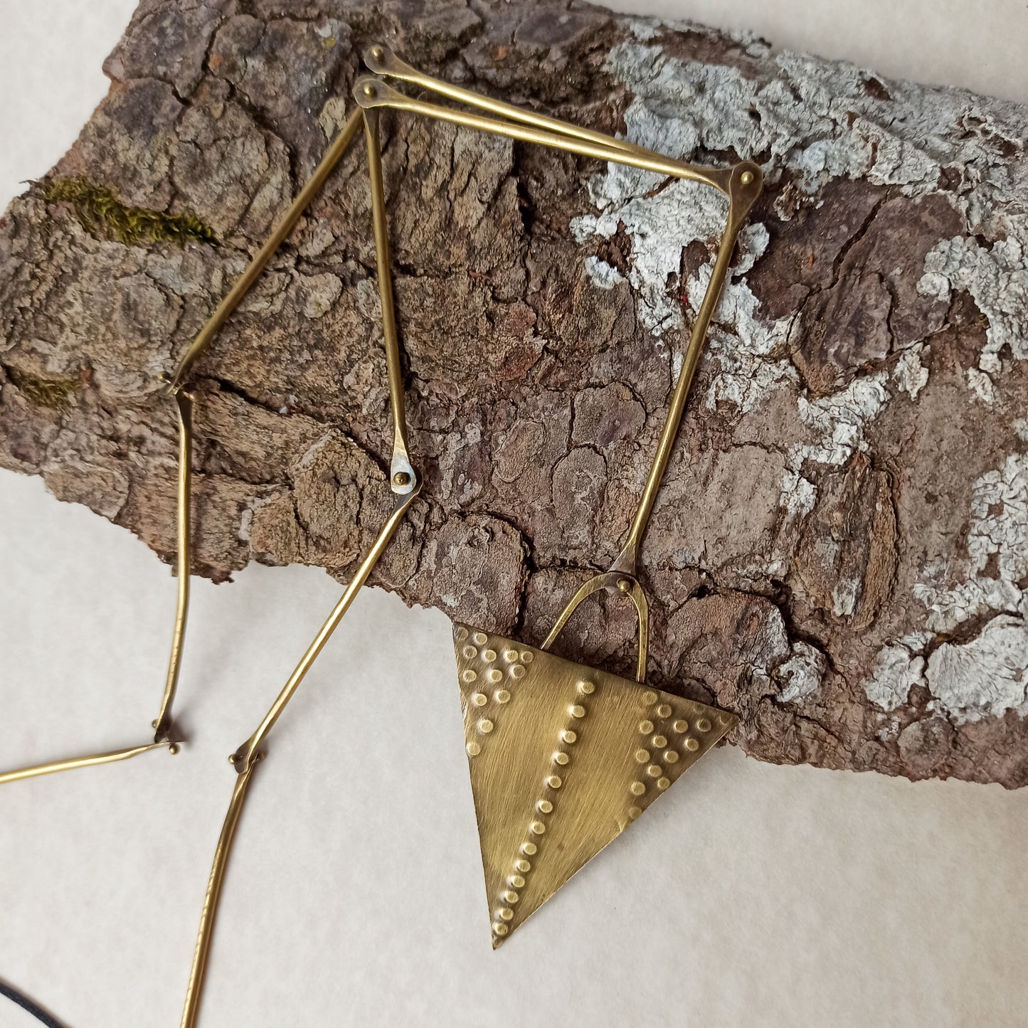 Handmade long necklace from oxidized brass. The center part is made from handtextured brass sheet and the chain is handmade from brass wire. The part that rests on the neck is from black satin cord. A lariat style totally handmade necklace ideal to make your outfit stand out.