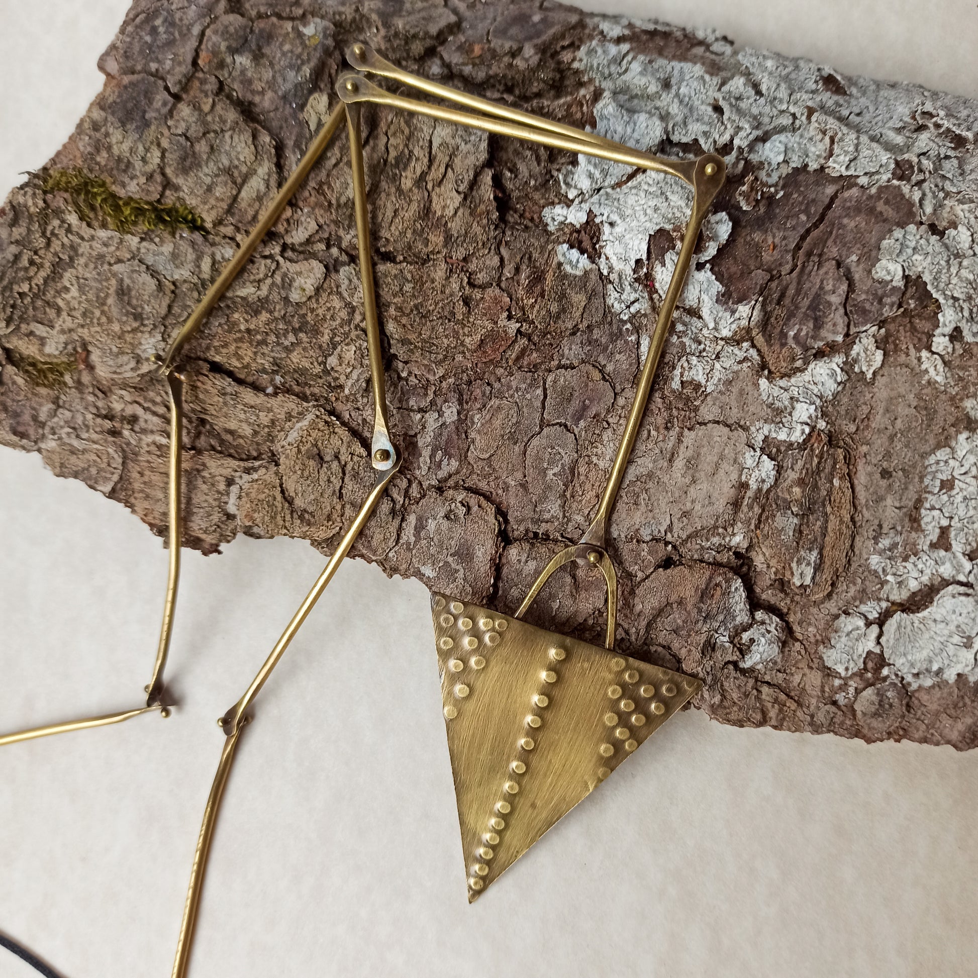 Handmade long necklace from oxidized brass. The center part is made from handtextured brass sheet and the chain is handmade from brass wire. The part that rests on the neck is from black satin cord. A lariat style totally handmade necklace ideal to make your outfit stand out.