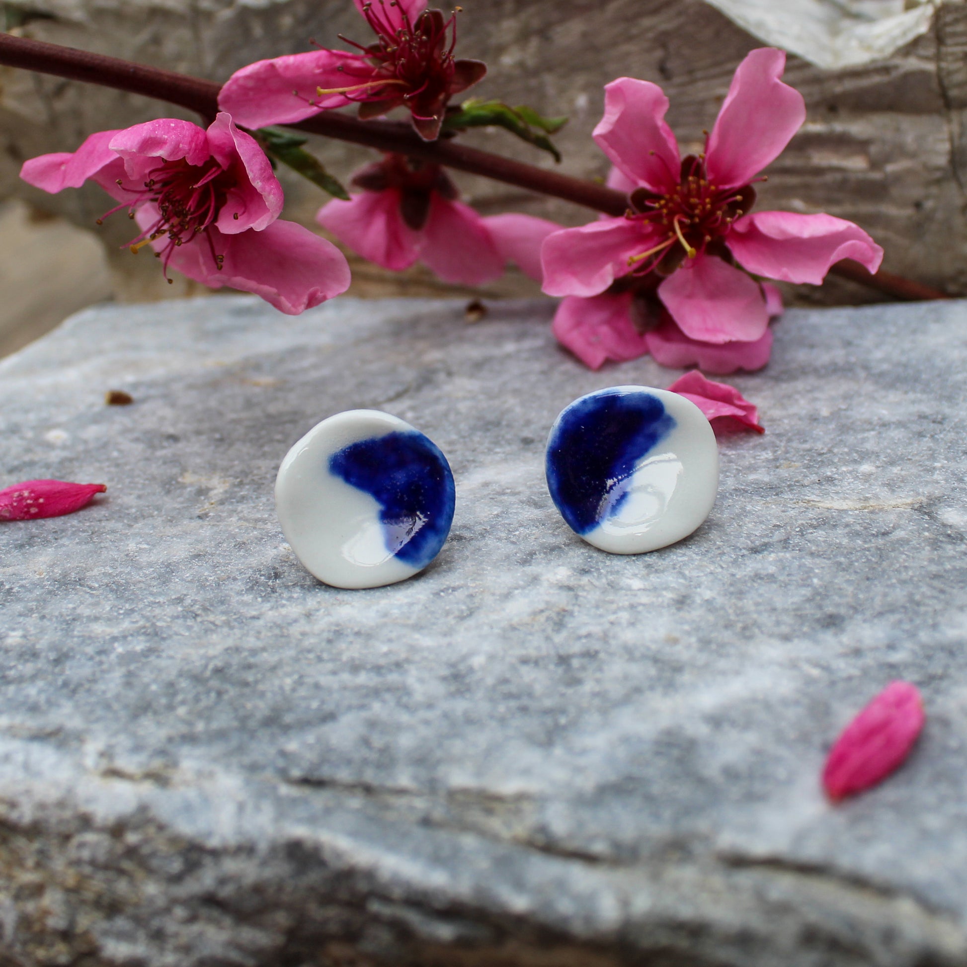 Little circle stud earrings made from white porcelain and blue stain with stainless steel posts.  Diameter of earrings is 1.80cm