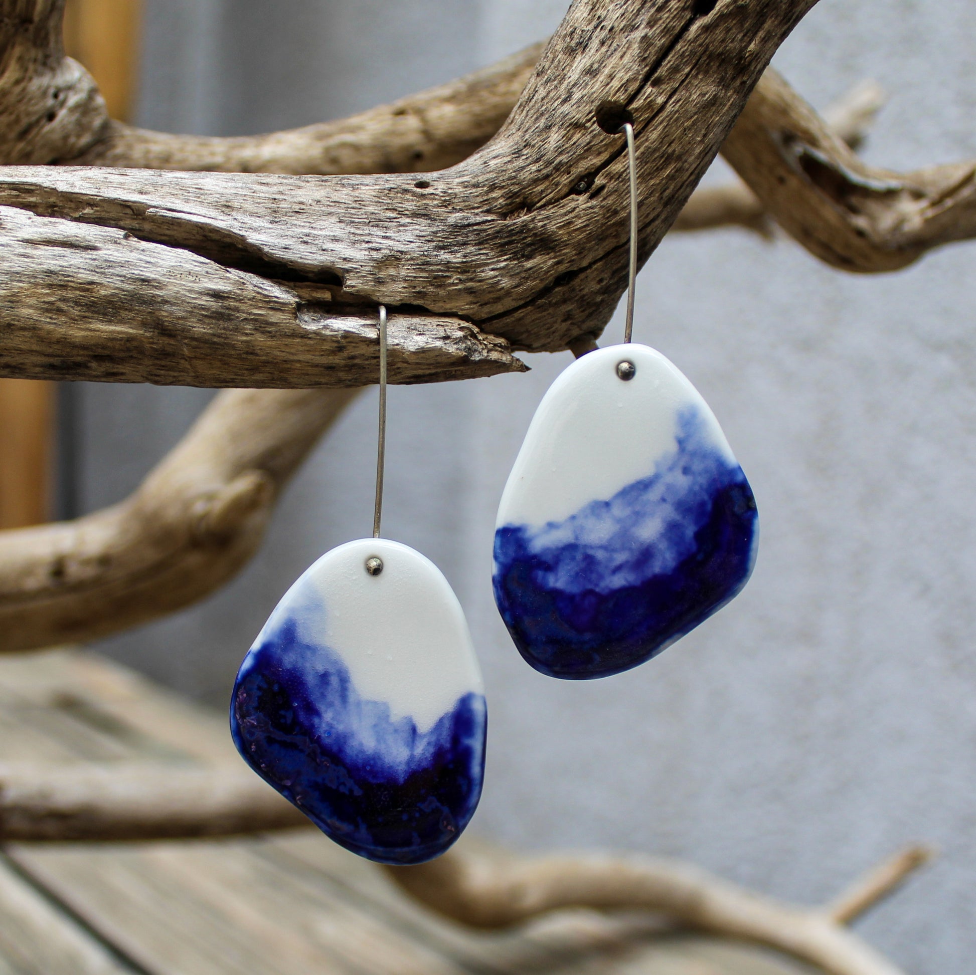 Long dangle earrings from white porcelain, hand painted with blue oxide. They hang from handmade oxidized sterling silver ear wire.