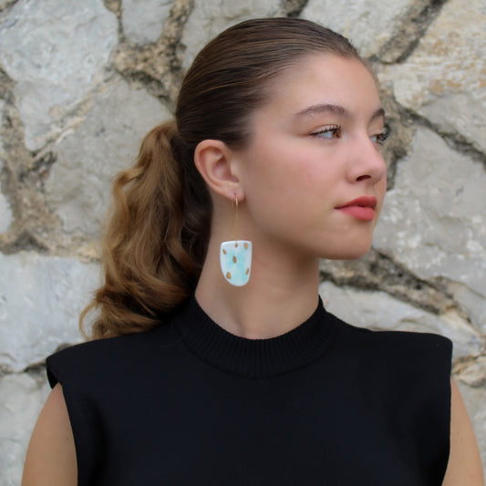White porcelain drop earrings with aquamarine  and gold luster spots. Hanging from long gold plated  earhooks.